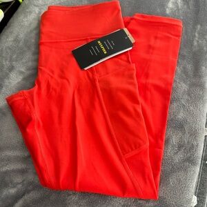 Athleta color bright Orange Leggings, two side pockets, inseam 25” size M.
